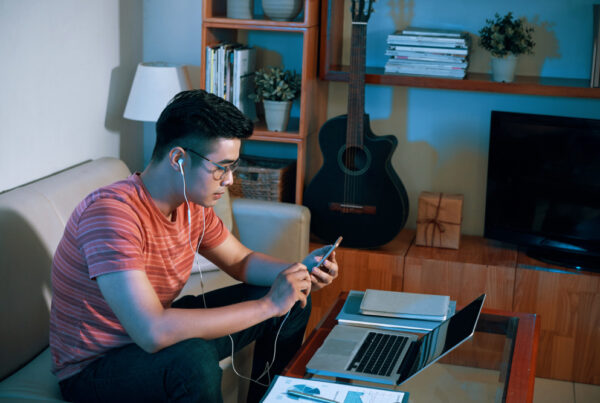 Pria bekerja dari rumah menggunakan laptop dan smartphone dengan koneksi WiFi rumah yang stabil